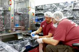 Offenders inspecting juice pouches at the beverage processing plant.