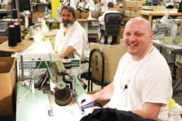 Inmates smiling while working at the sewing shop in Gunnison Utah