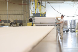 Inmate rolling out textiles on large table