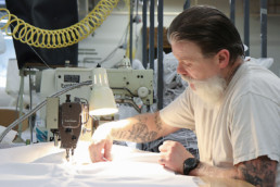 Inmate sewing textiles with sewing machine