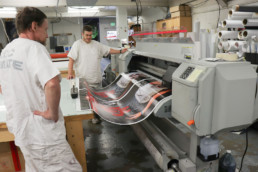 Inmates printing a large banner with large machine