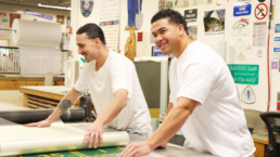 Offenders working on laminating a road sign.