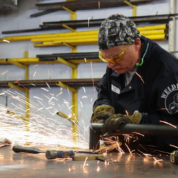 Inmate grinding a piece of metal